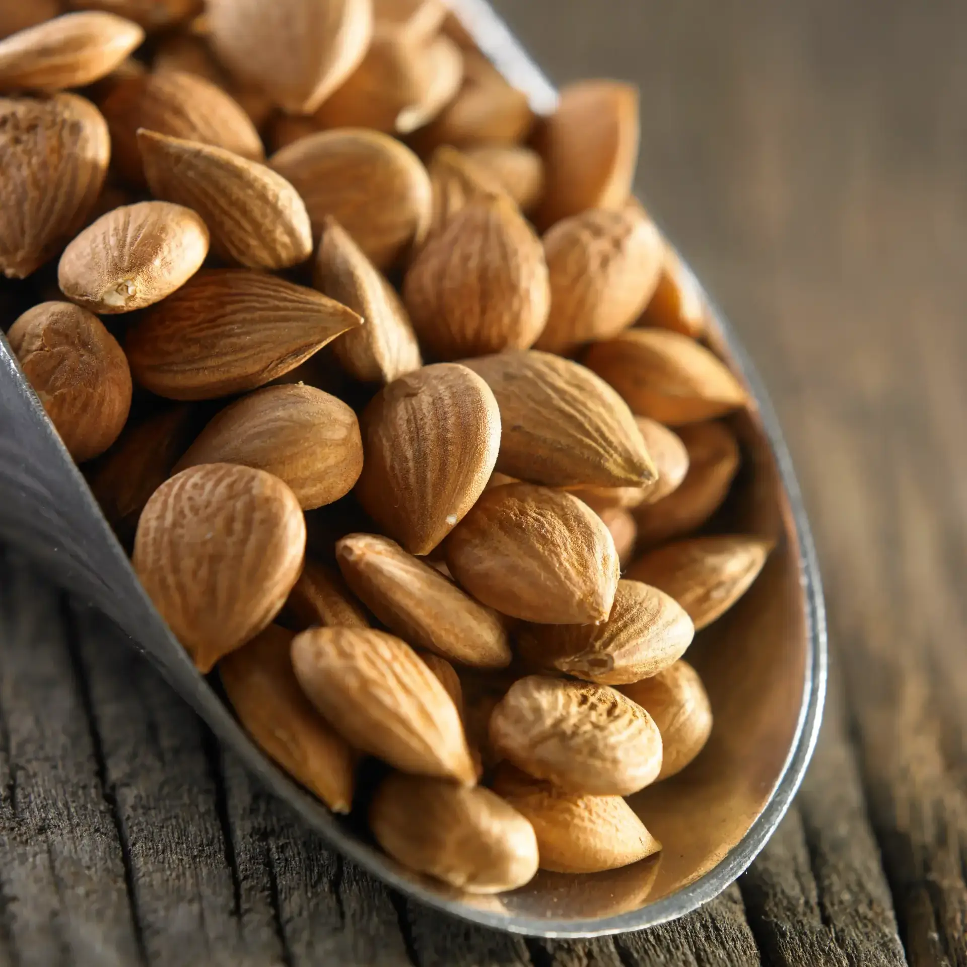 Close-up of almonds in a wooden spoon, a natural source of vitamin E