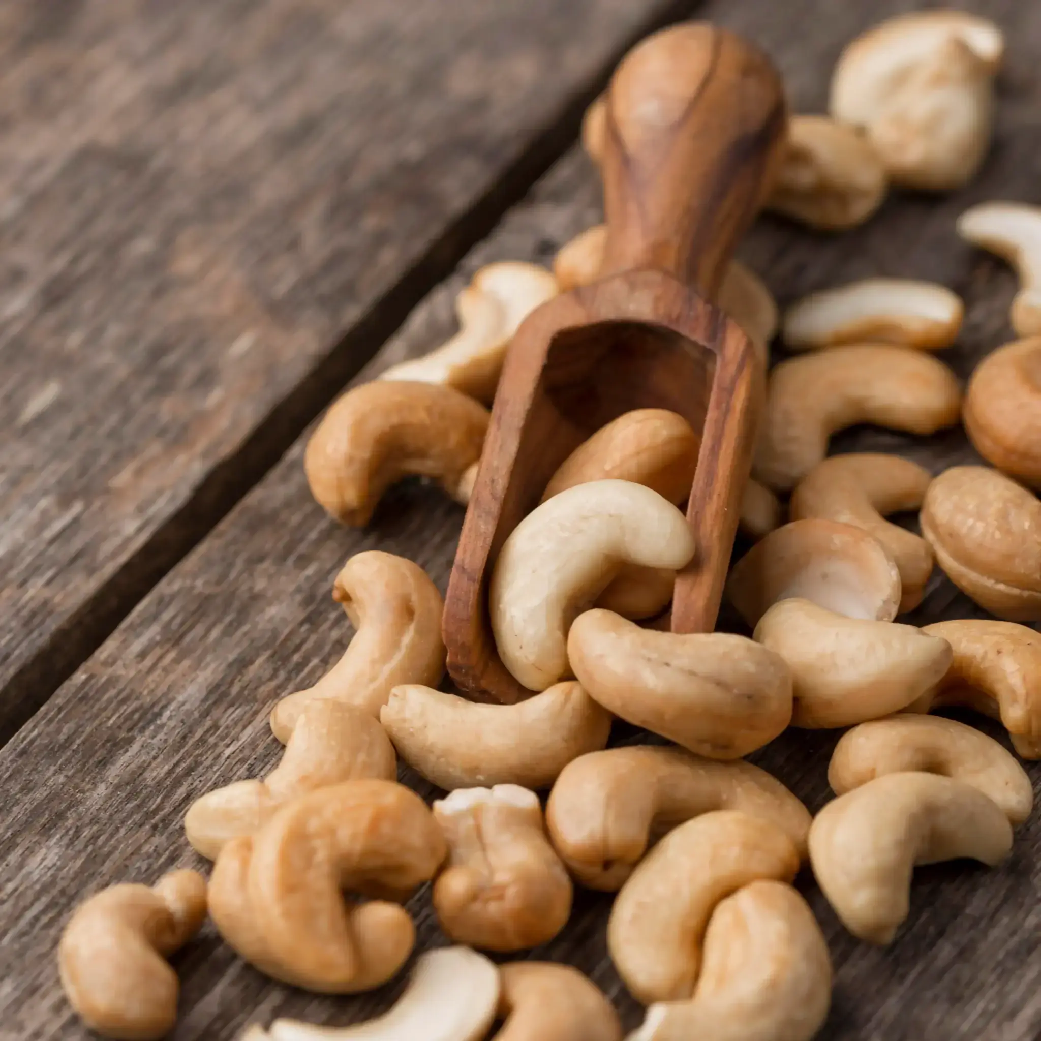 Yerba Mate and copper - raw cashew nuts on a wooden spoon, a real source of copper in the diet