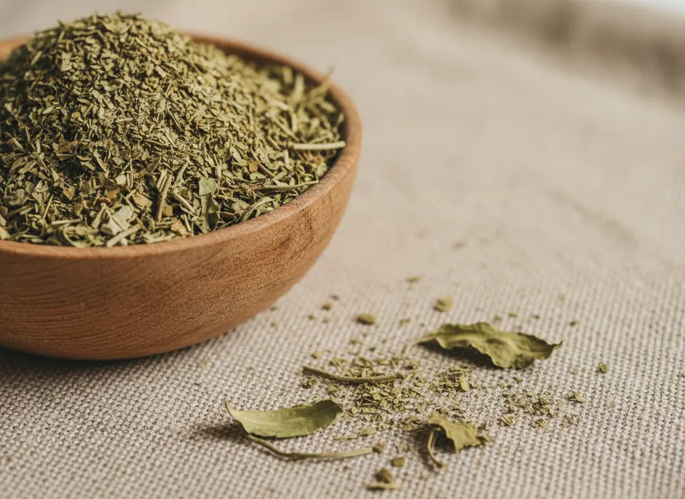 Dried yerba mate leaves in a wooden bowl - natural support for concentration