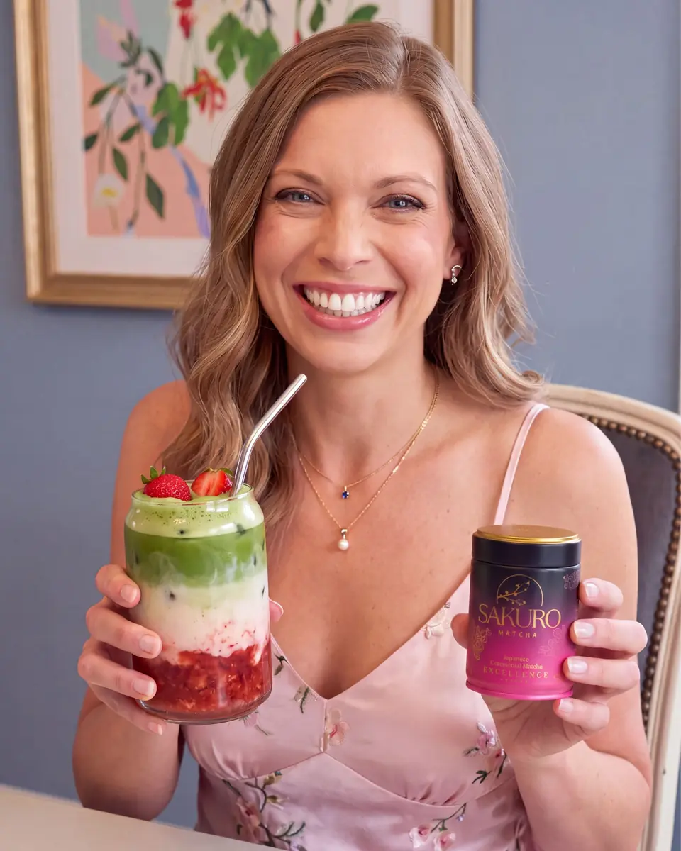 Laughing woman with a strawberry matcha latte and a Sakuro tin