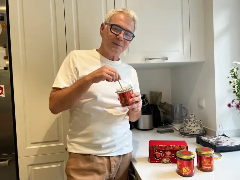 Man in the kitchen with Yerbador honey, jars and a gift box on the counter