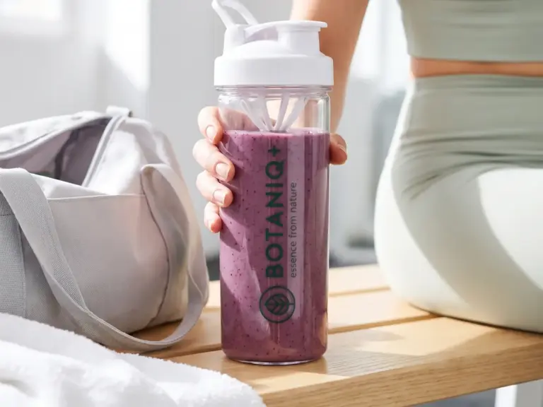 Shaker with açaí smoothie in hand after a workout