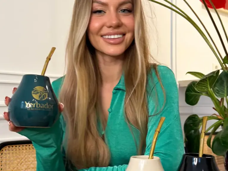 Woman in a green sweater with a collection of Yerbador materos