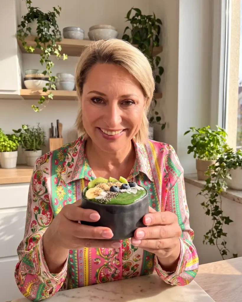 Moringa: smiling woman holding a green bowl in a black Fuji bowl